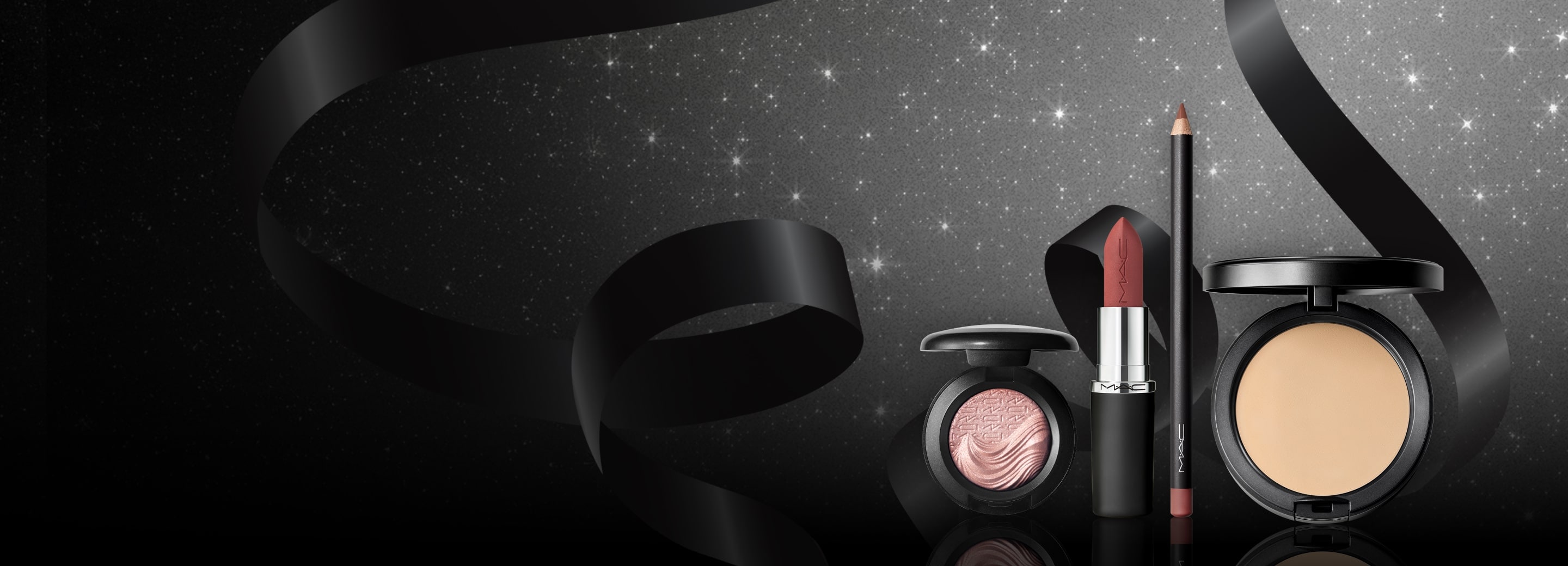 eyeshadow, lipstick, lipliner and powder on black background